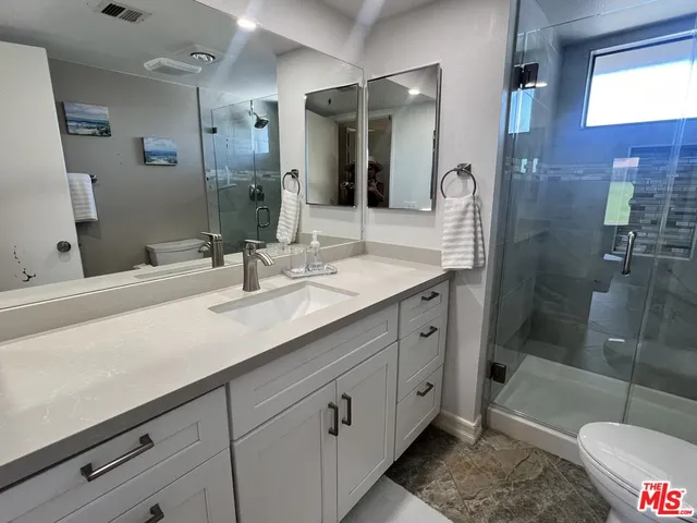 a bathroom with a shower sink and mirror
