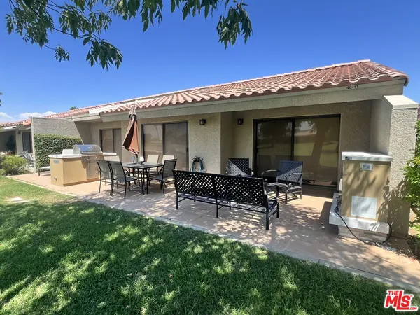 a view of a patio with table and chairs with wooden fence