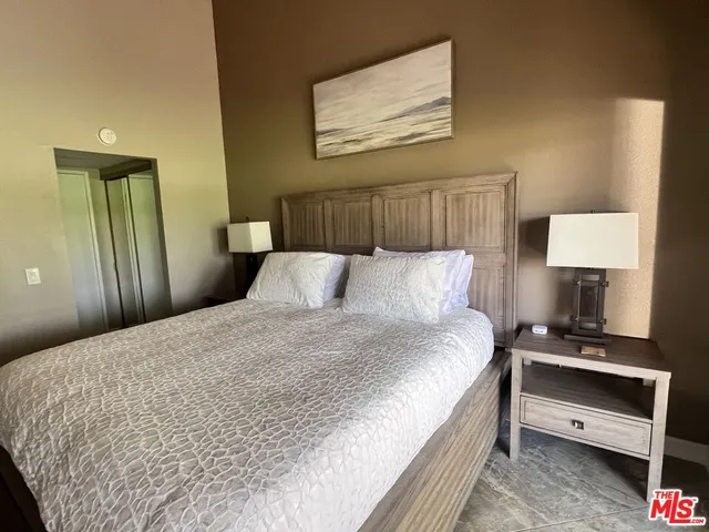 a large bed in a bedroom next to a lamp