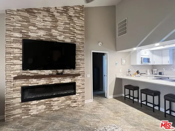 a view of kitchen with kitchen island stainless steel appliances and cabinets