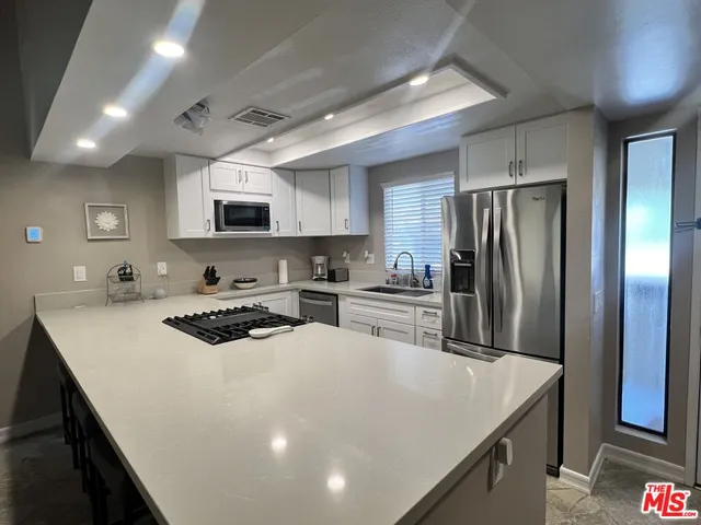 a kitchen with a appliances a sink and a refrigerator