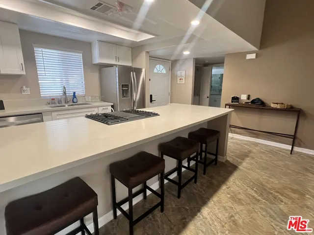 a kitchen with a table chairs sink and cabinets