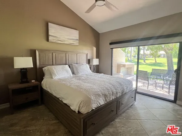 a large bed sitting in a bedroom next to a window