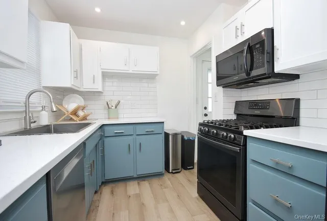 a kitchen with stainless steel appliances granite countertop a sink stove and microwave