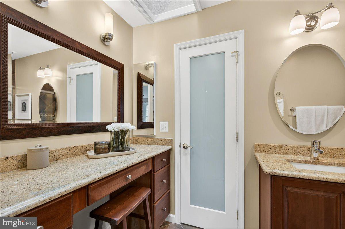 7723 Silver Sage Court Springfield, VA 22153 - Photo 33 of 63 a bathroom with a granite countertop sink a large mirror and a window