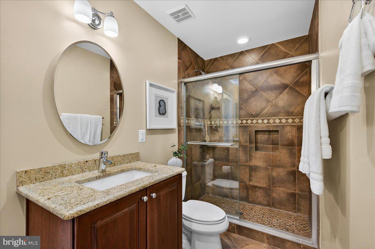 7723 Silver Sage Court Springfield, VA 22153 - Photo 34 of 63 a bathroom with a granite countertop sink toilet mirror and shower