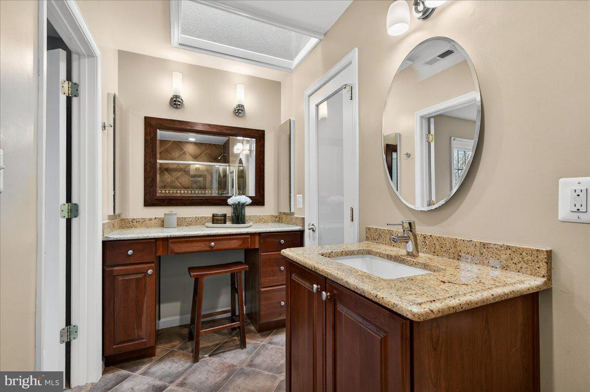 7723 Silver Sage Court Springfield, VA 22153 - Photo 35 of 63 a bathroom with a granite countertop sink and a mirror