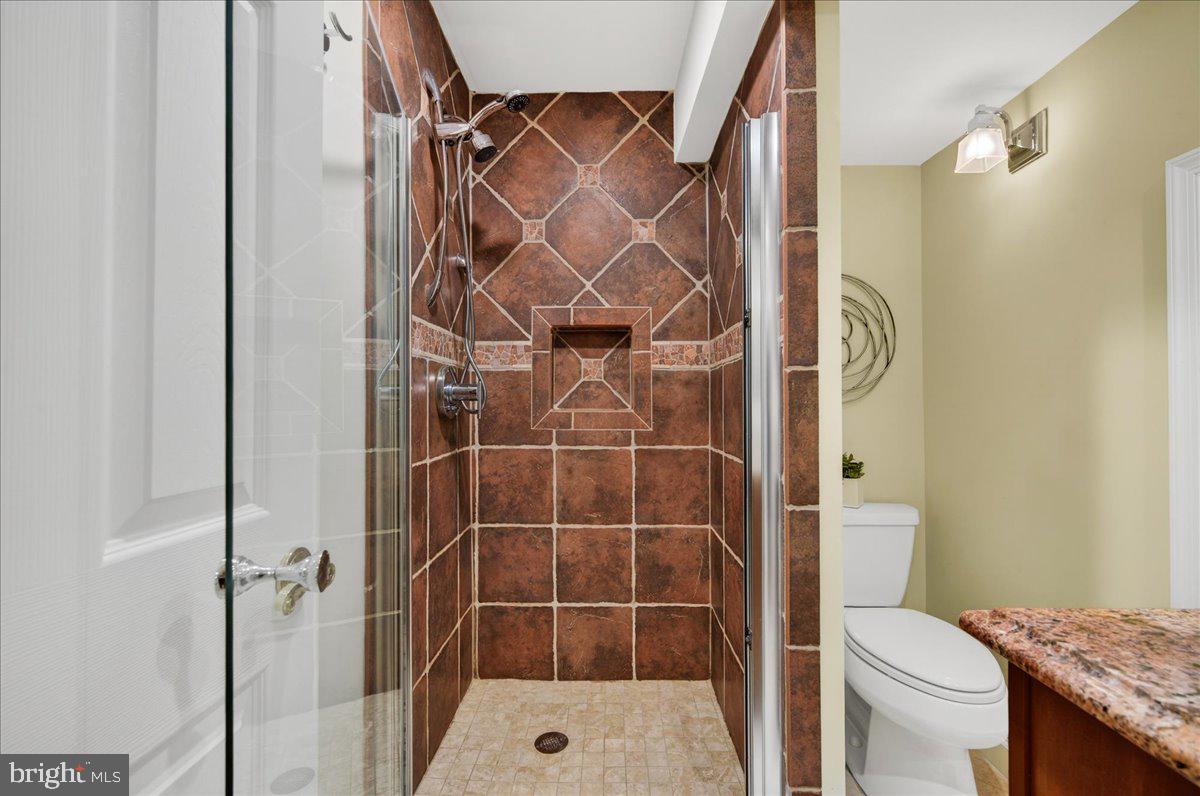7723 Silver Sage Court Springfield, VA 22153 - Photo 52 of 63 a bathroom with a granite countertop sink toilet and shower