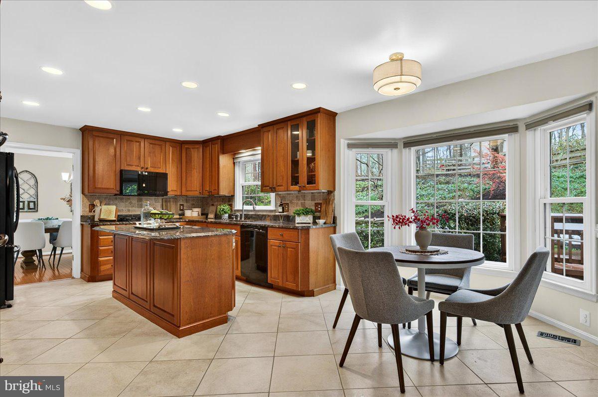 7723 Silver Sage Court Springfield, VA 22153 - Photo 7 of 63 a kitchen with stainless steel appliances granite countertop a stove a refrigerator a kitchen island with chairs and a refrigerator