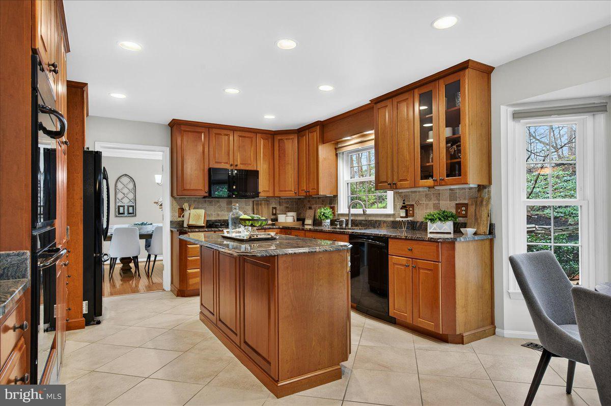7723 Silver Sage Court Springfield, VA 22153 - Photo 10 of 63 a kitchen with stainless steel appliances granite countertop wooden cabinets a sink a stove a refrigerator and a stove