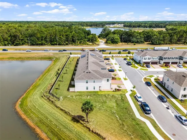 a view of a swimming pool with lawn chairs and a yard