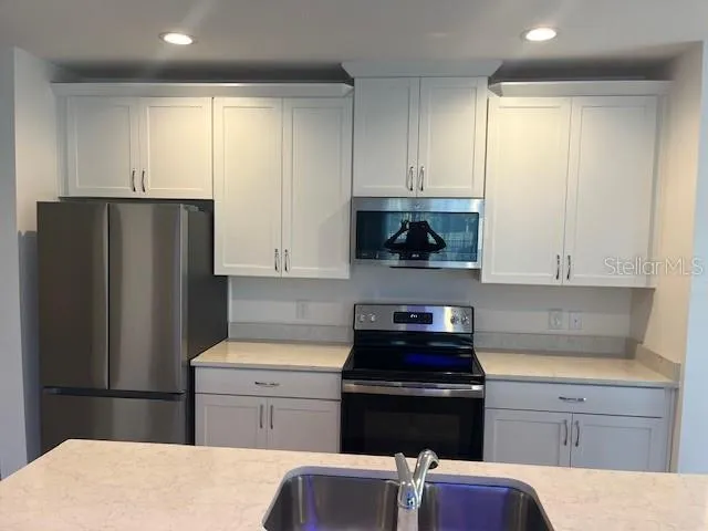 a kitchen with a refrigerator and cabinets