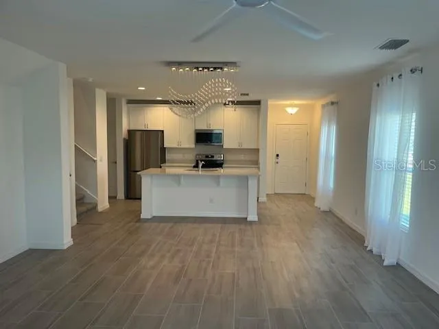 a large kitchen with cabinets and wooden floor