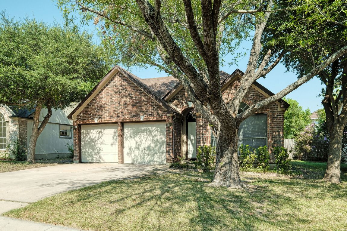 1304 Garden Path Cove Round Rock, TX 78664 - Photo 1 of 14 View of front facade with brick siding, concrete driveway, a garage, and a front yard