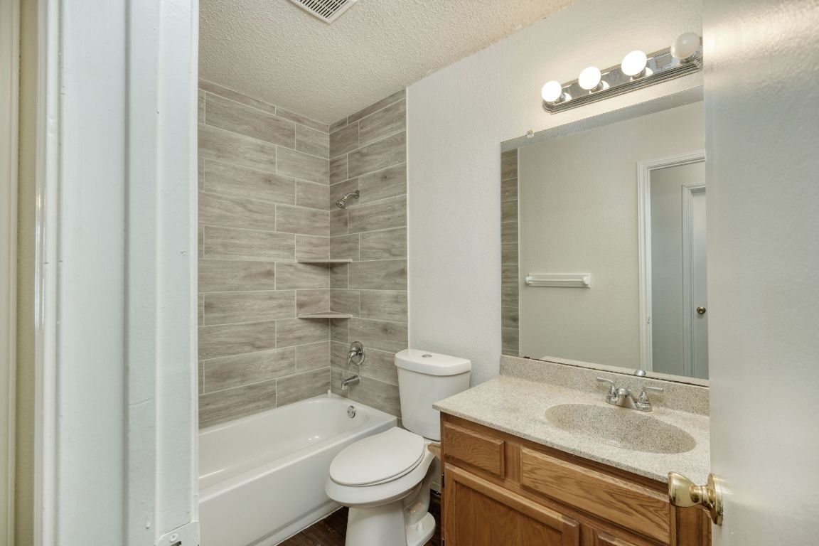 1304 Garden Path Cove Round Rock, TX 78664 - Photo 10 of 14 Bathroom with a textured ceiling, shower / washtub combination, and vanity
