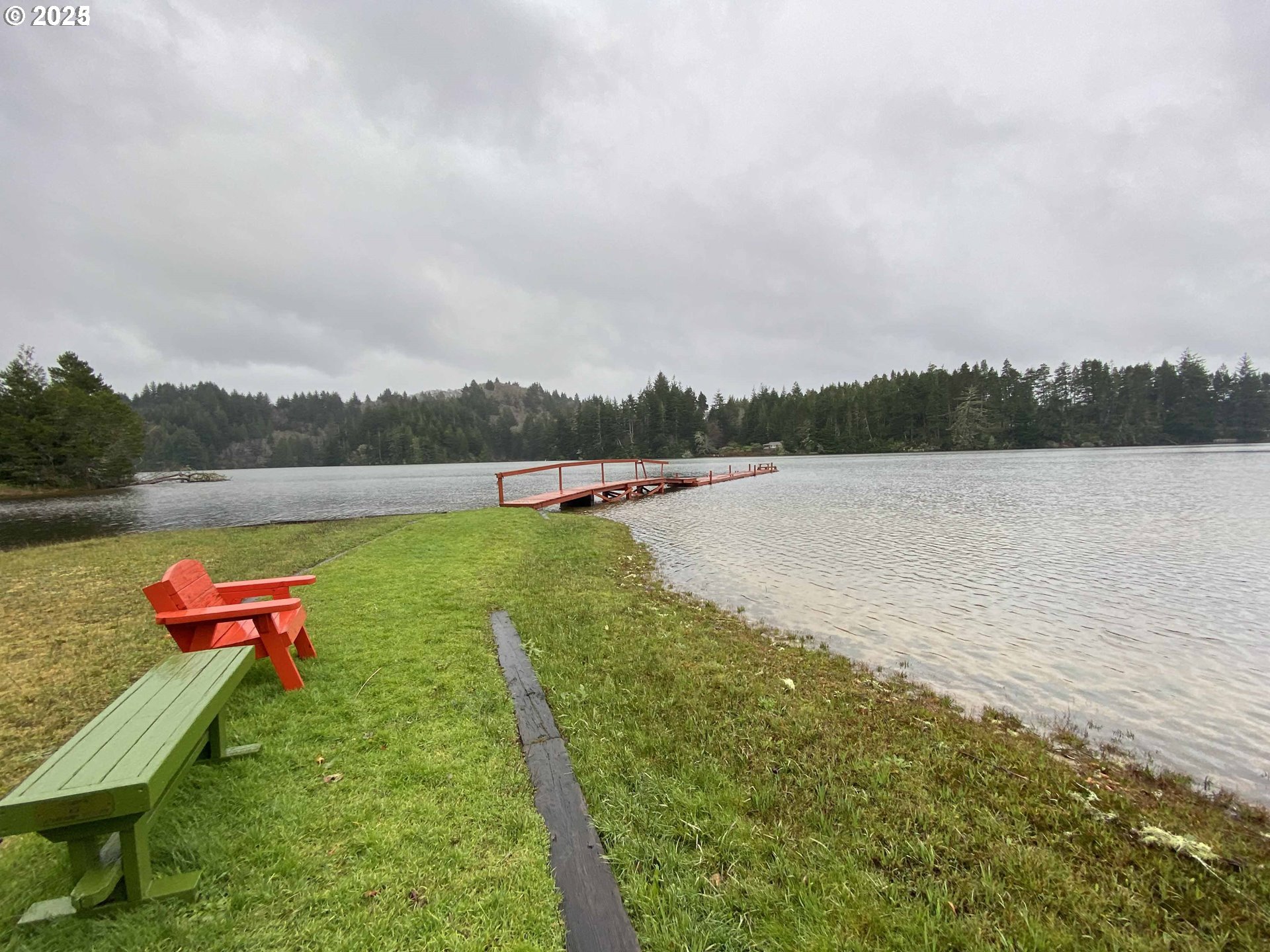 Nordahl Road Florence, OR 97439 - Photo 18 of 20 a view of lake with table and chairs and wooden fence