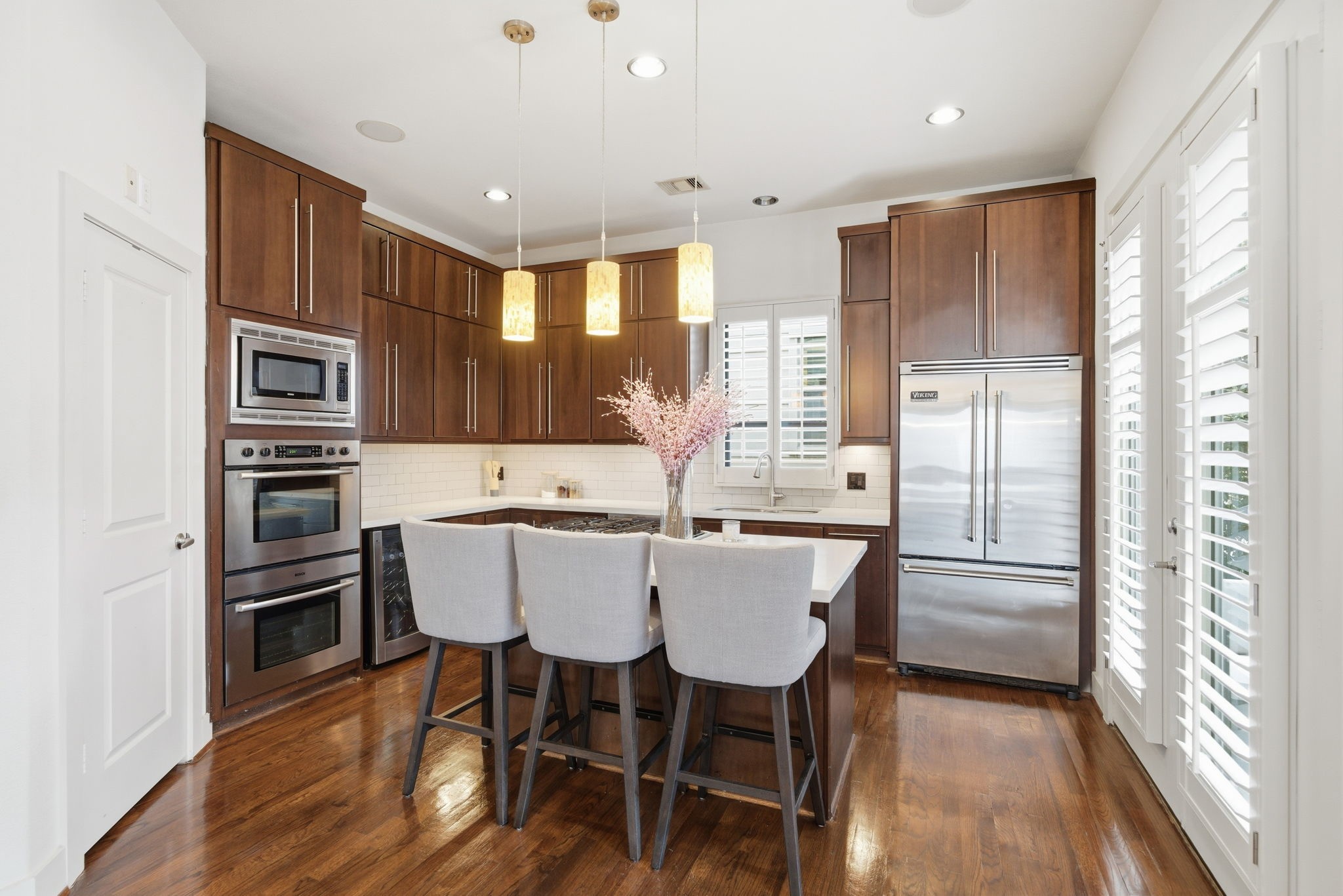 4129 Dickson Street Houston, TX 77007 - Photo 15 of 36 a kitchen with stainless steel appliances granite countertop a stove a refrigerator a kitchen island and chairs with wooden floor