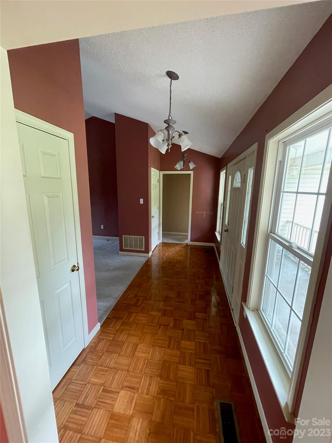 4 Grace Anna Lane Alexander, NC 28701 - Photo 18 of 38 a hallway with wooden floor windows and a chandelier