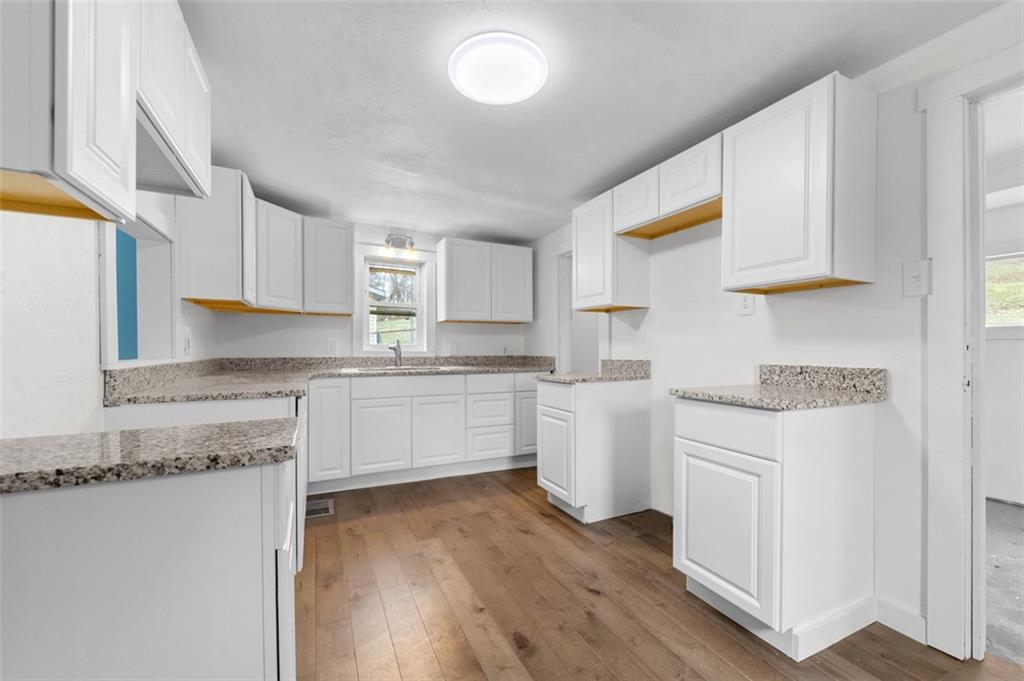 242 Union Street Dickerson Run, PA 15430 - Photo 4 of 17 a kitchen with granite countertop white cabinets and white appliances