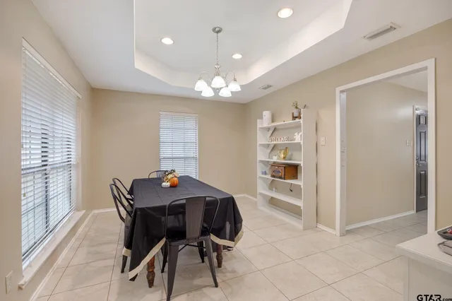 a view of a dining room with furniture and a chandelier