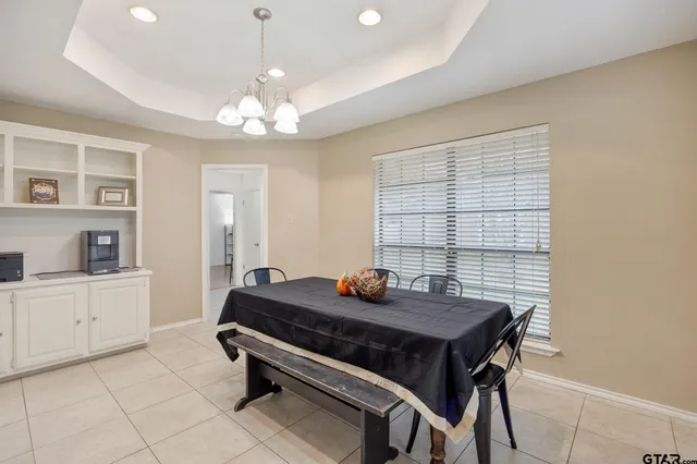 a living room with a table chairs and a chandelier