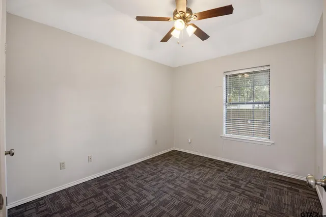 an empty room with a window and a fan