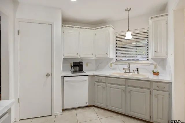 a kitchen with white cabinets and white appliances