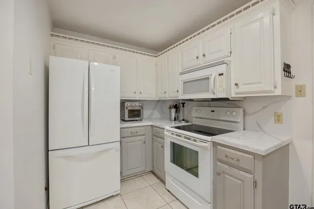 a kitchen with white cabinets and white appliances