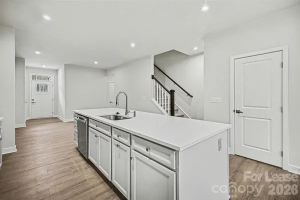 a kitchen with a sink and wooden floor