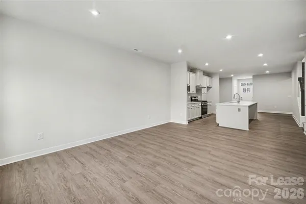 a view of kitchen with a refrigerator wooden floor and a window