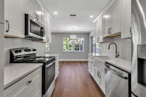a kitchen with stainless steel appliances a sink stove and cabinets
