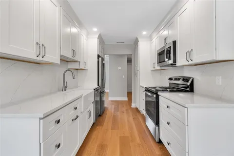 a kitchen with stainless steel appliances granite countertop a stove a sink and a refrigerator