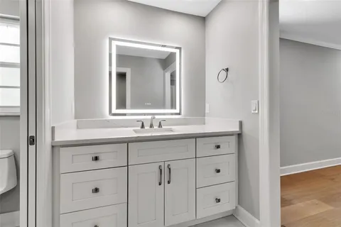 a bathroom with a granite countertop sink a mirror and a shower