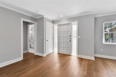a view of an empty room with window and wooden floor