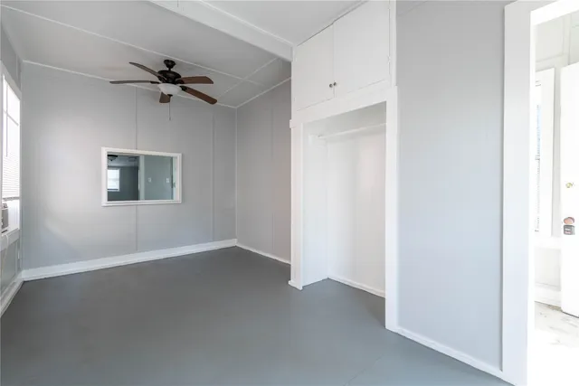 a view of a room with a ceiling fan and a window