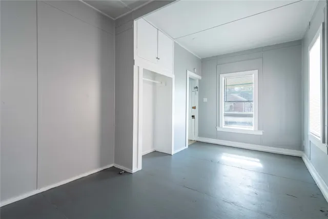 an empty room with windows and closet