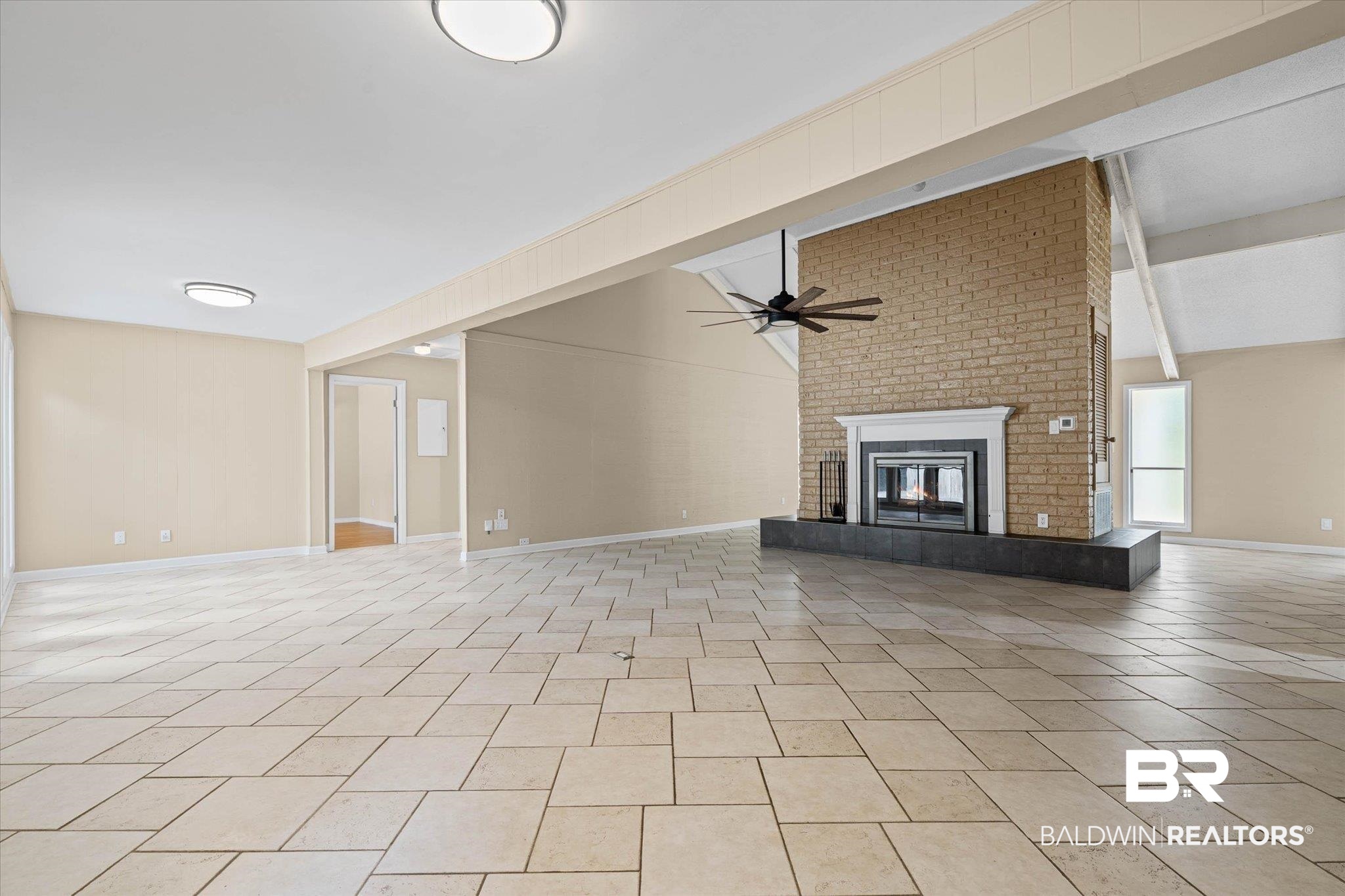 3724 Claridge Road South Mobile, AL 36608 - Photo 5 of 42 Unfurnished living room featuring a ceiling fan, a brick fireplace, lofted ceiling, and light tile patterned floors