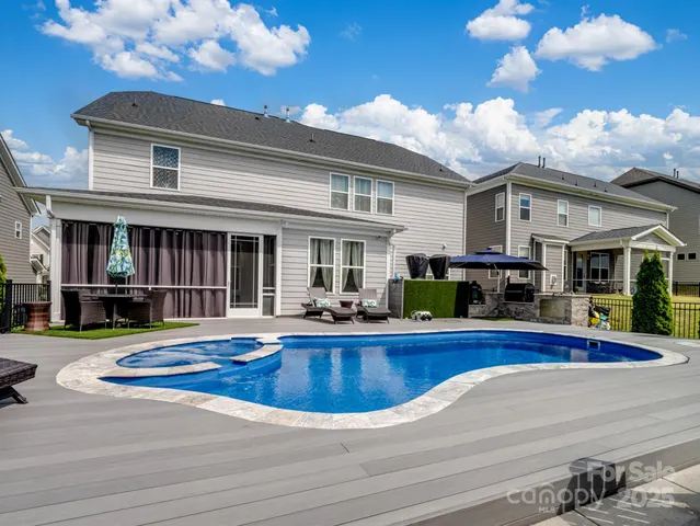 a view of a house with swimming pool and sitting area