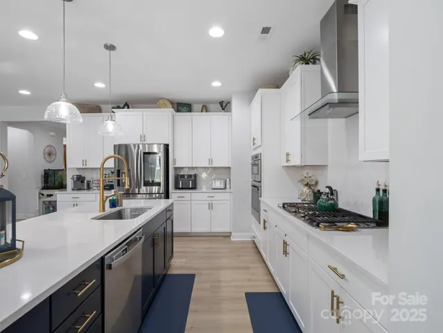 a kitchen with stainless steel appliances kitchen island granite countertop a sink and cabinets