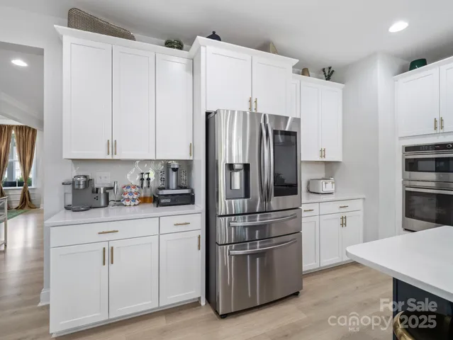 a kitchen with white cabinets and stainless steel appliances