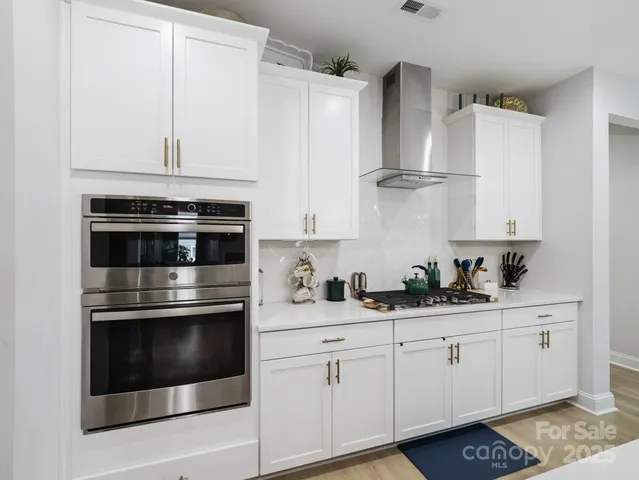 a kitchen with granite countertop white cabinets and white appliances