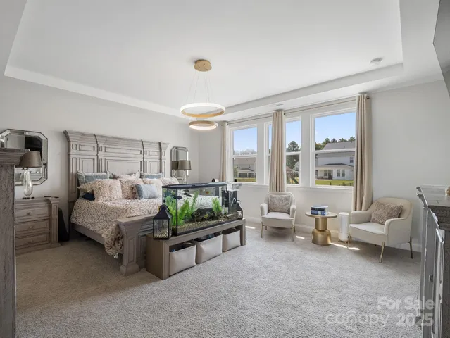 a spacious bedroom with furniture and a large window