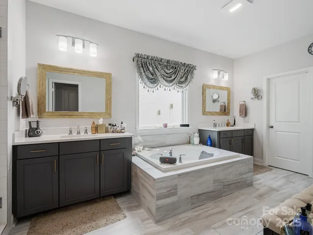 a bathroom with a tub a sink and mirror