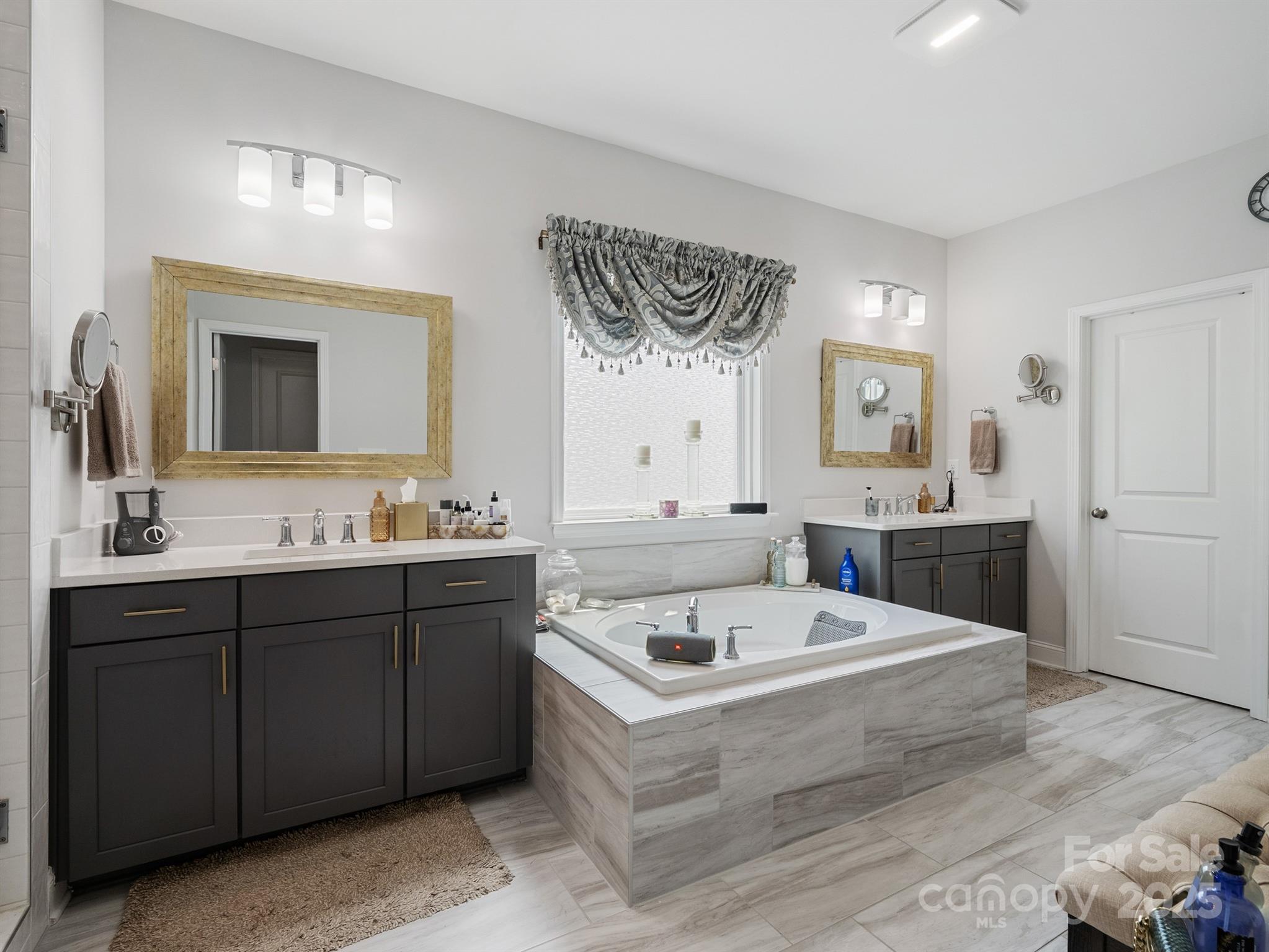 15213 Shallow Ridge Road Charlotte, NC 28278 - Photo 30 of 48 a bathroom with a tub a sink and mirror