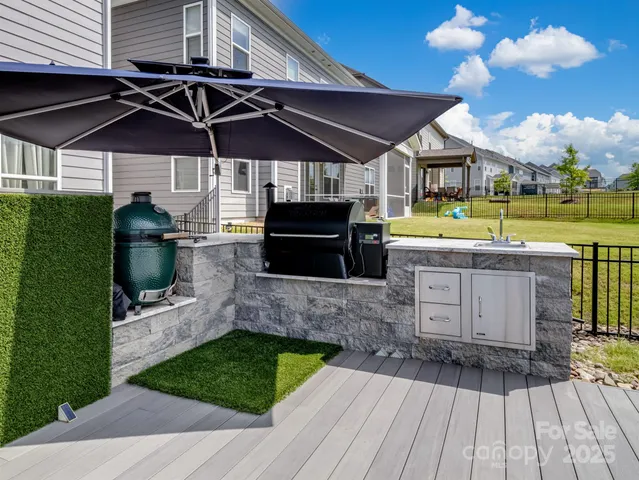 a view of a chairs and table in the patio with a barbeque