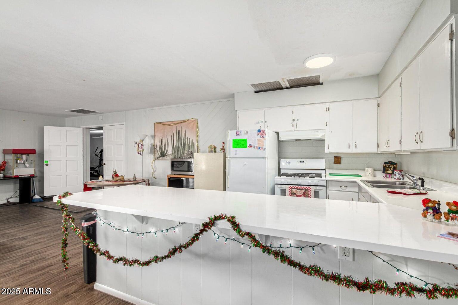 16225 North Cave Creek Road, Unit 1 Phoenix, AZ 85032 - Photo 24 of 33 a kitchen with stainless steel appliances kitchen island granite countertop a sink and cabinets