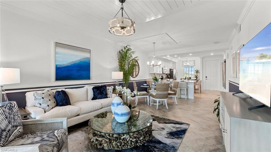 5583 Double Eagle Circle, Unit 4134 Immokalee, FL 34142 - Photo 2 of 32 a living room with lots of furniture and a chandelier