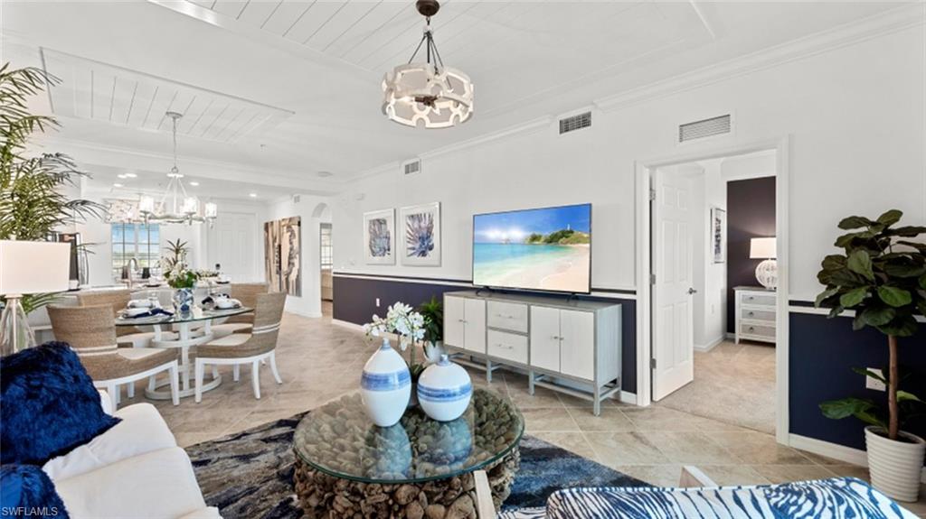 5583 Double Eagle Circle, Unit 4134 Immokalee, FL 34142 - Photo 3 of 32 a living room with furniture a chandelier and a dining table