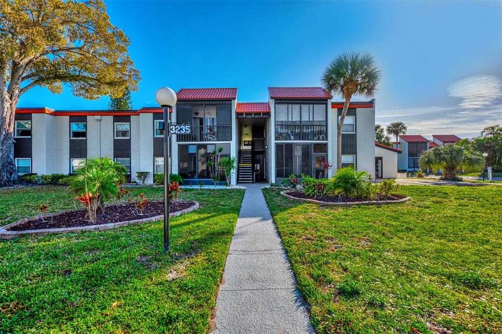 a front view of a house with a yard and potted plants