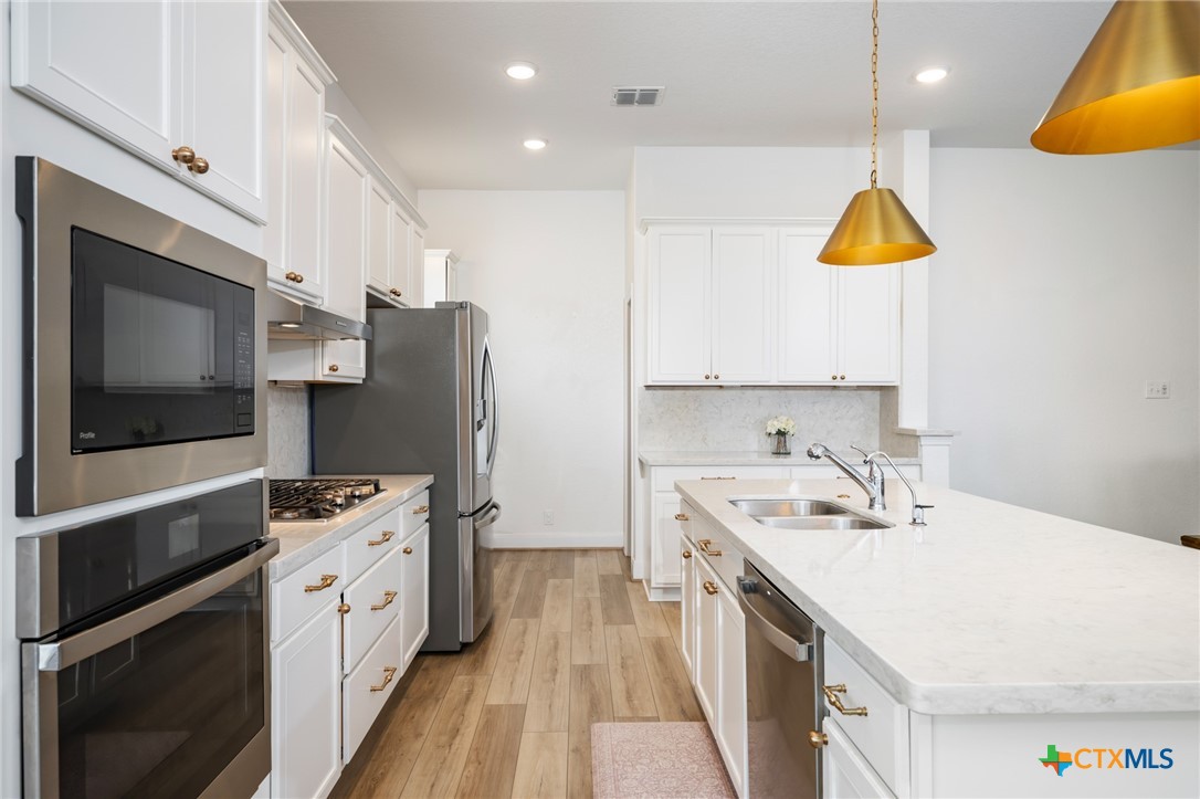 2939 Rems New Braunfels, TX 78130 - Photo 15 of 41 a kitchen with a sink a counter top space stainless steel appliances and cabinets